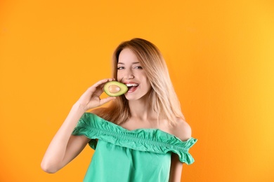 Photo of Portrait of young beautiful woman with ripe delicious avocado on color background