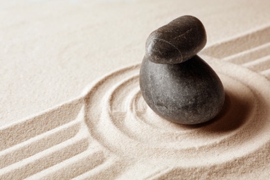 Photo of Stacked zen garden stones on sand with pattern, space for text. Meditation and harmony