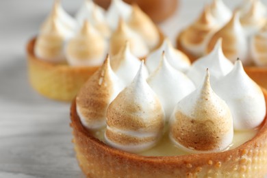 Photo of Tartlets with meringue on table, closeup. Tasty dessert