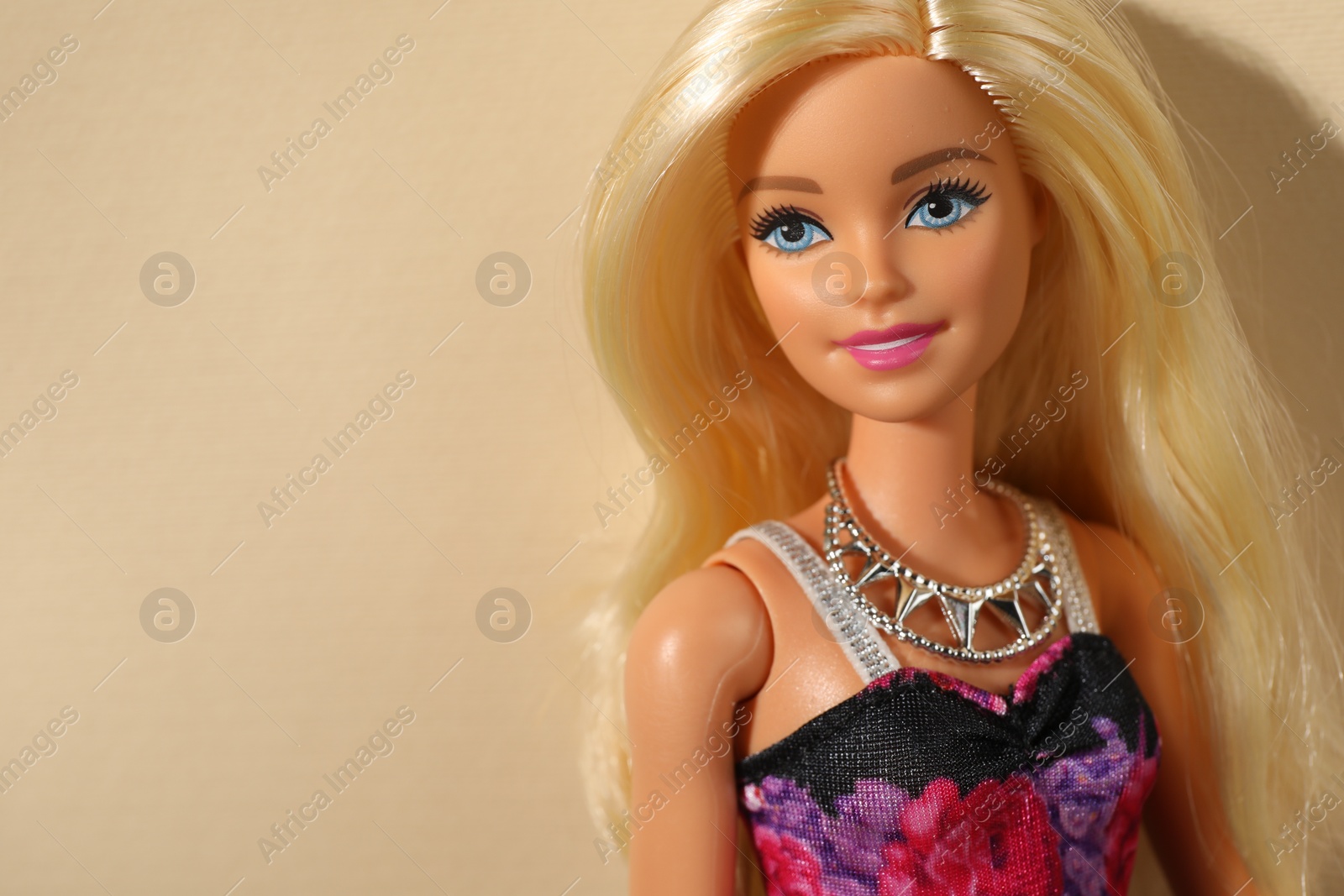 Photo of Mykolaiv, Ukraine - September 4, 2023: Beautiful Barbie doll wearing necklace on beige background, space for text