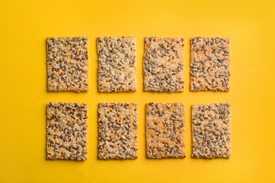 Delicious crackers on yellow background, flat lay