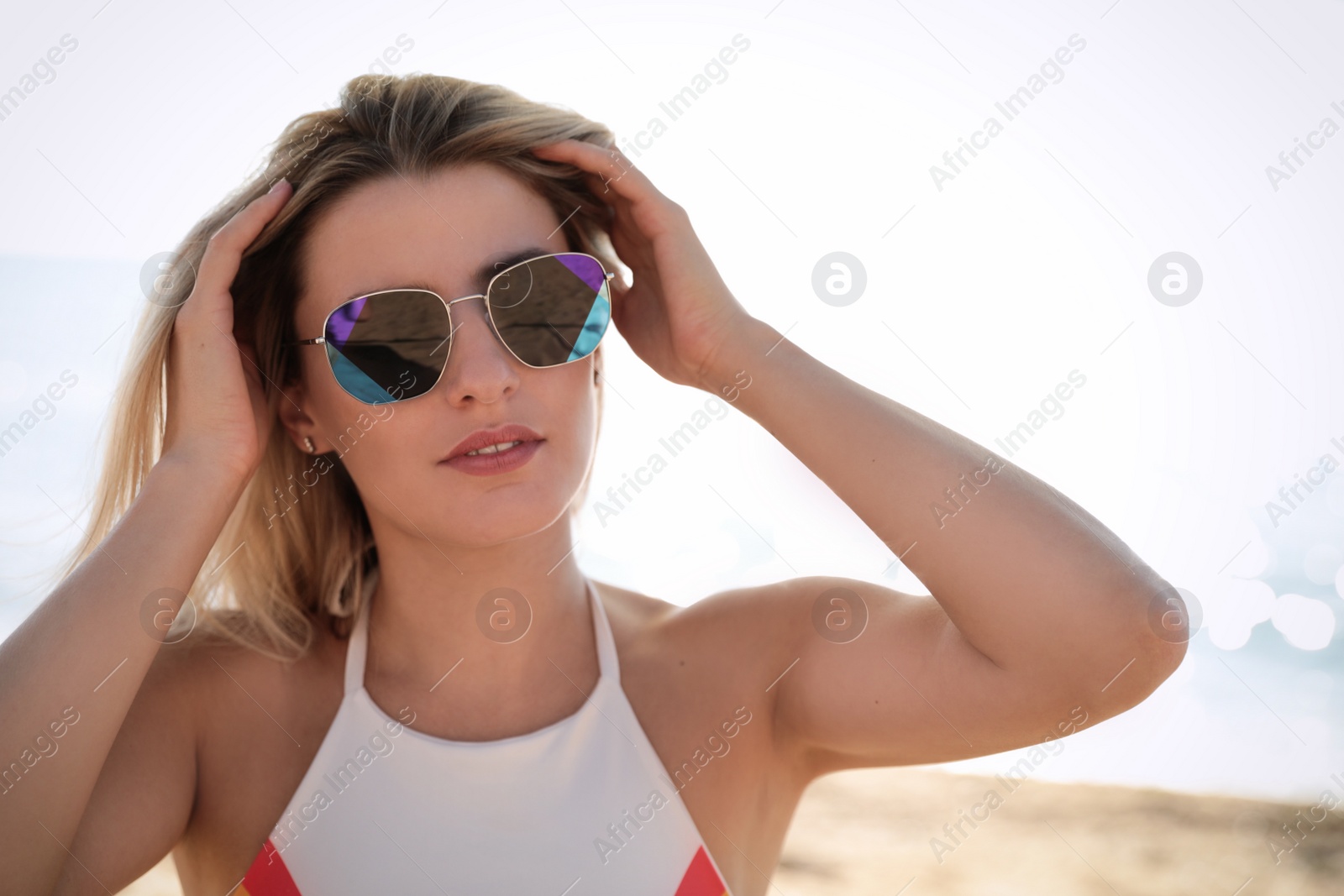 Photo of Beautiful woman wearing sunglasses at beach on sunny day