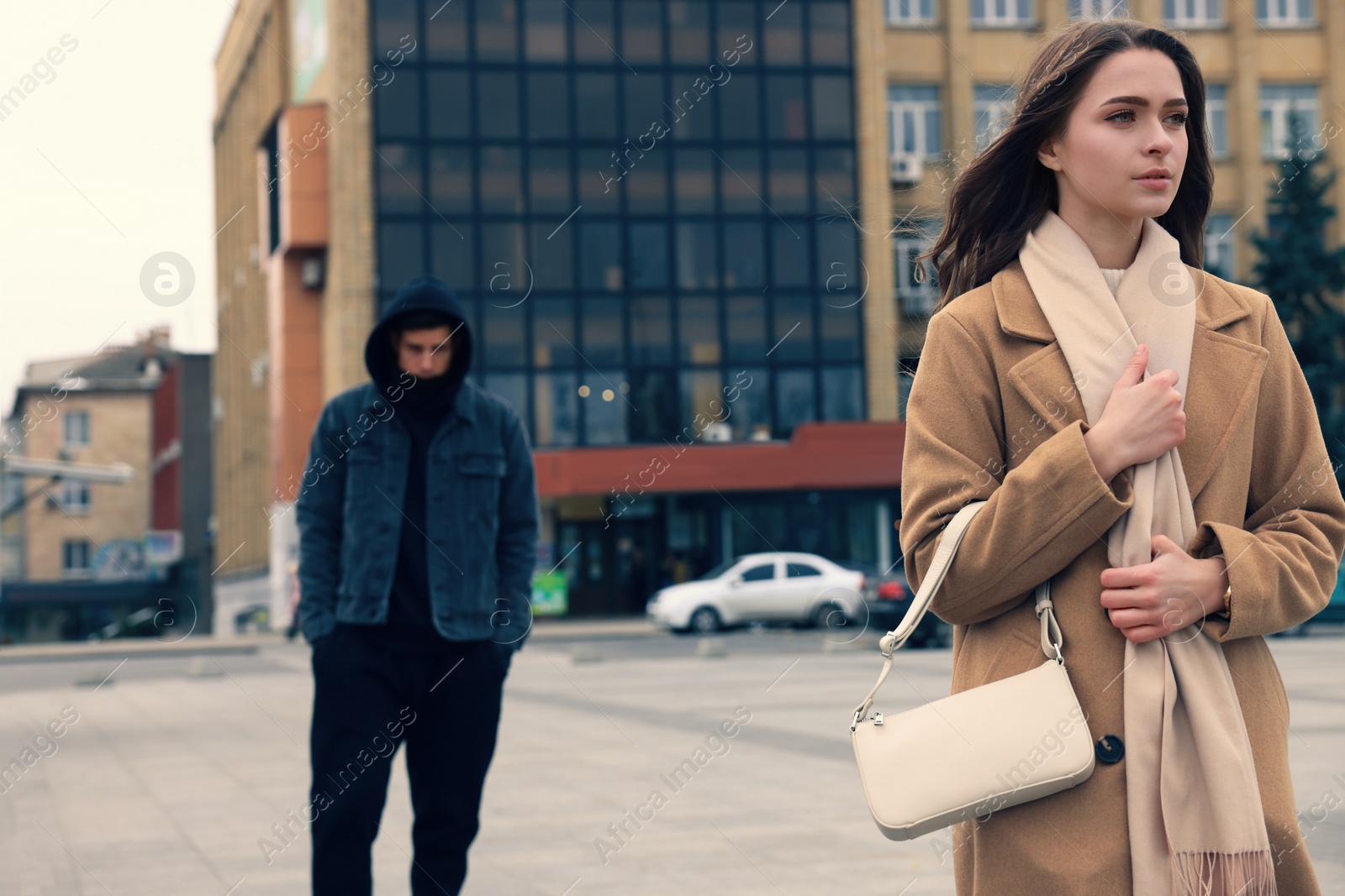 Photo of Man stalking young woman on city street