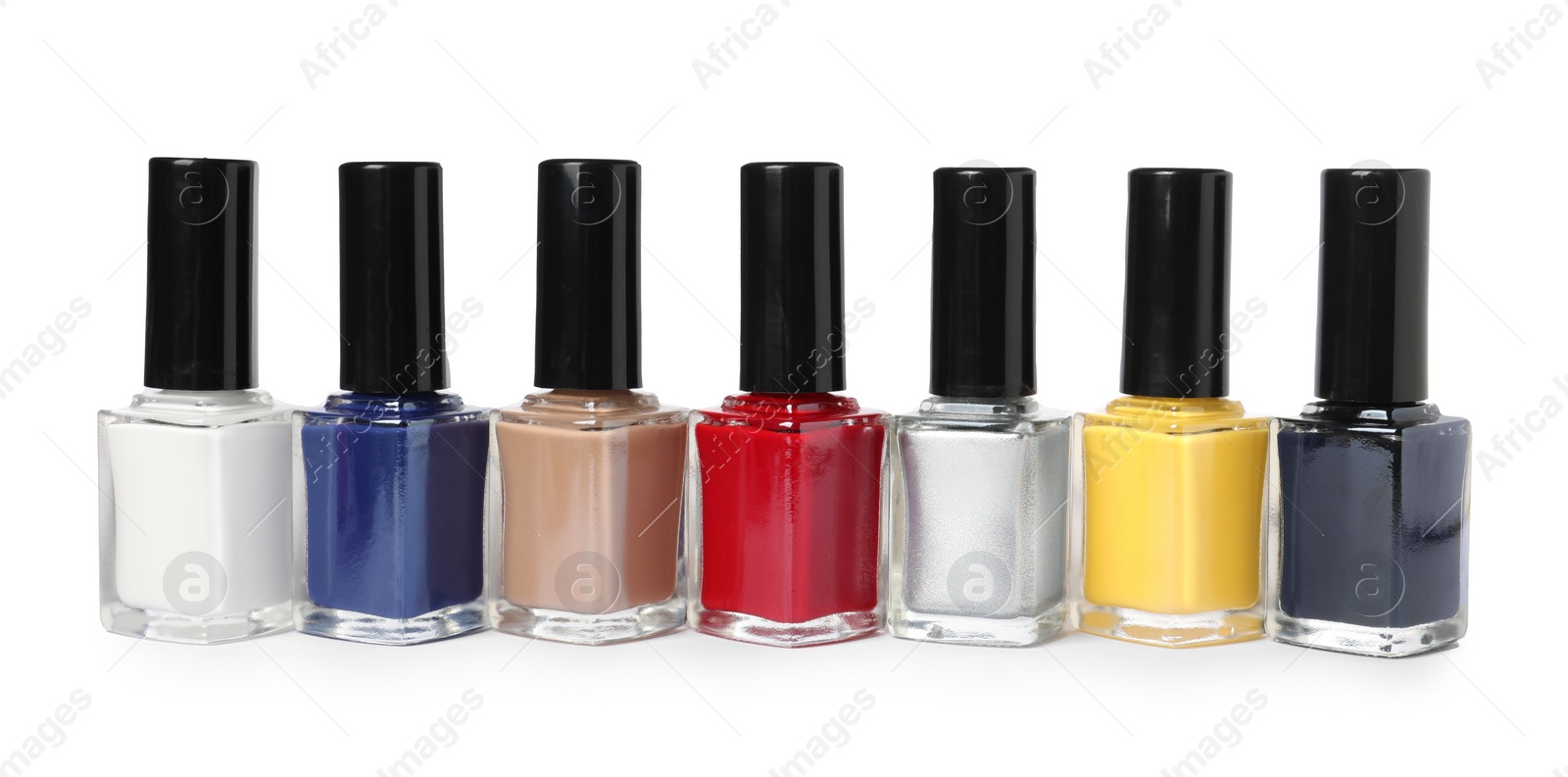 Photo of Bright nail polishes in bottles isolated on white