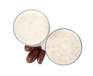 Glasses with delicious smoothie and dried dates on white background, top view