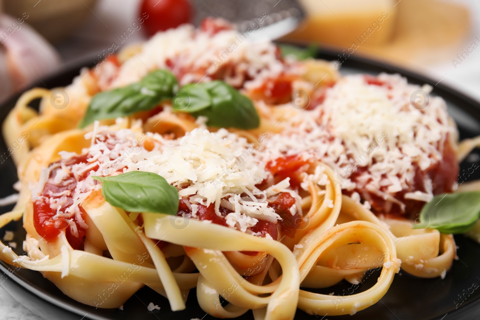 Photo of Delicious pasta with tomato sauce, basil and parmesan cheese in plate, closeup