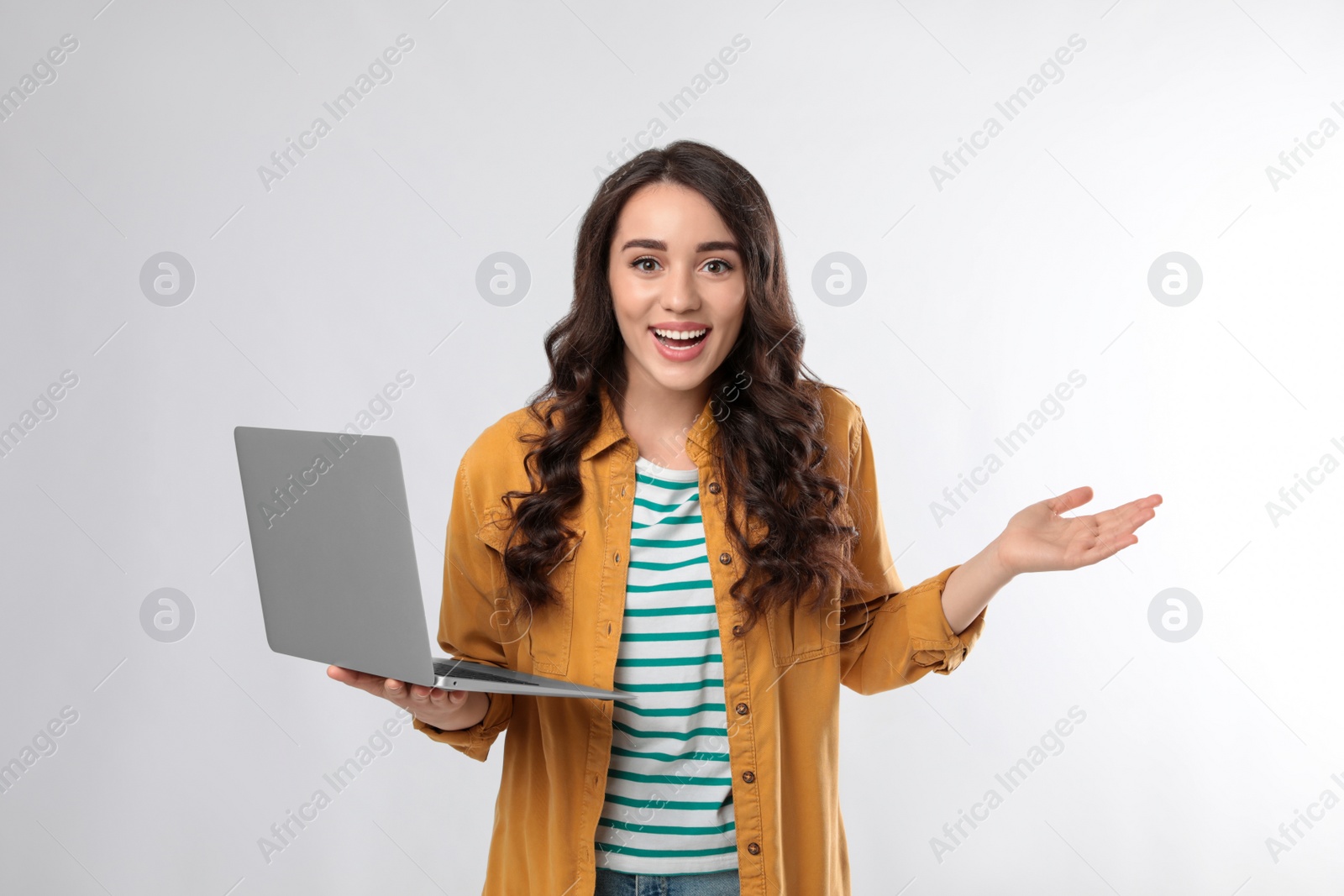 Photo of Surprised young woman with laptop on white background
