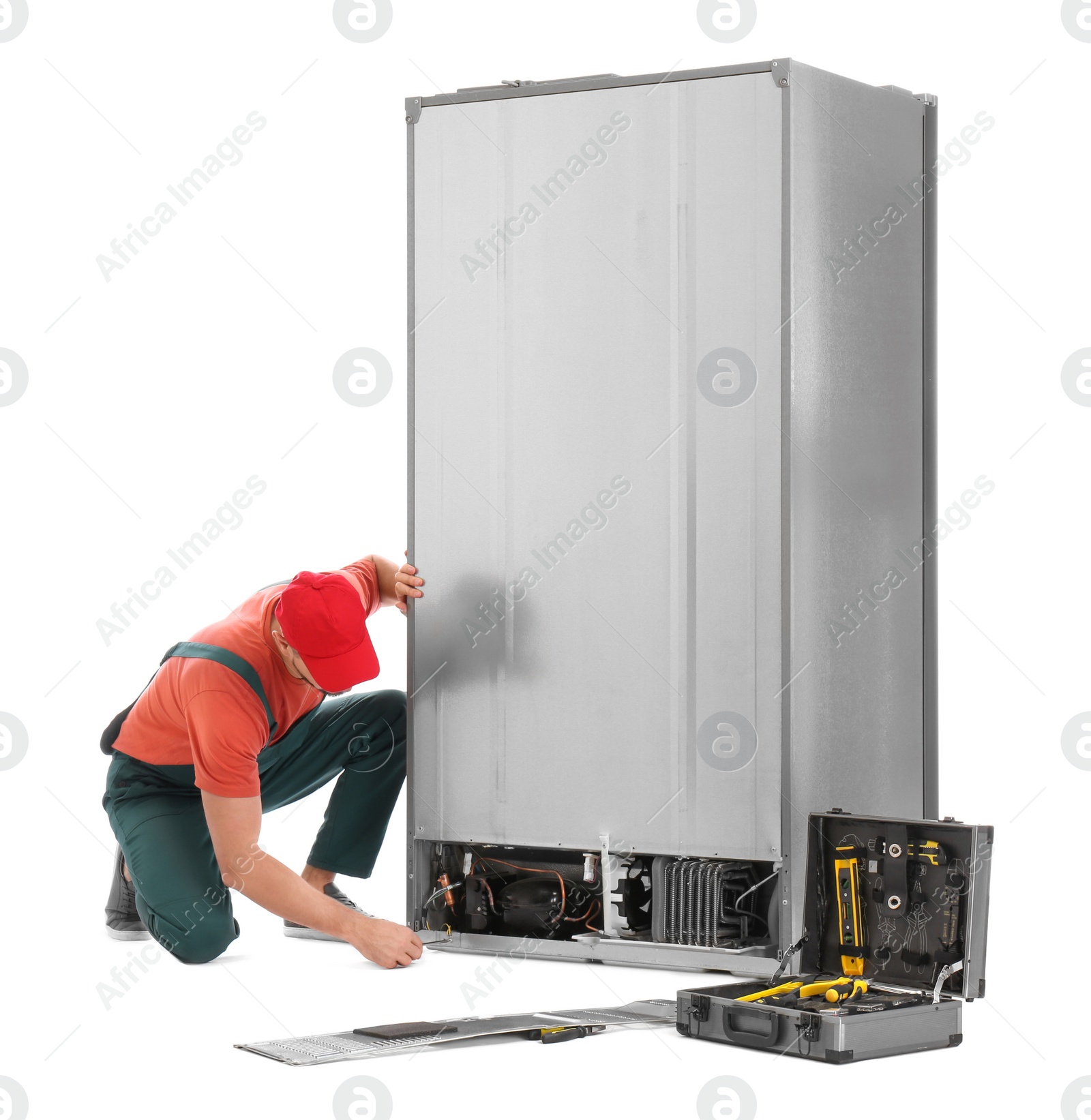 Photo of Male technician repairing refrigerator on white background