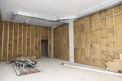 Photo of Wall with metal studs and insulation material indoors. Repair and maintenance