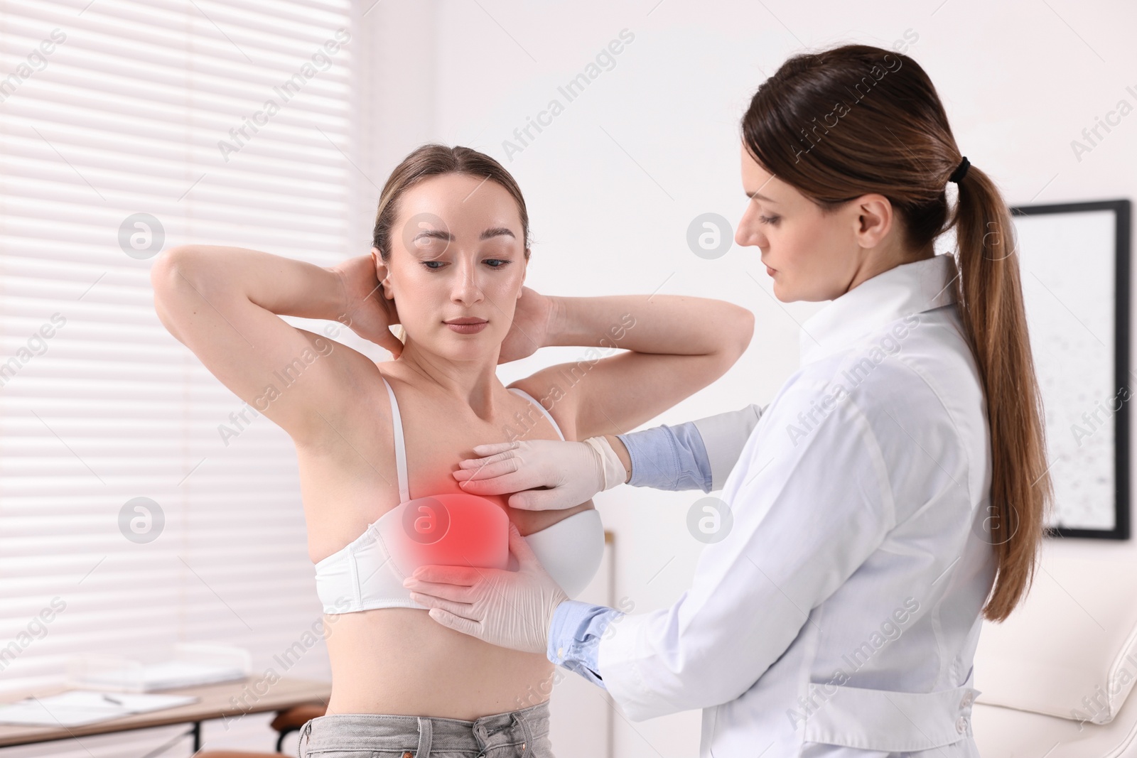 Image of Mammologist checking young woman's breast in hospital