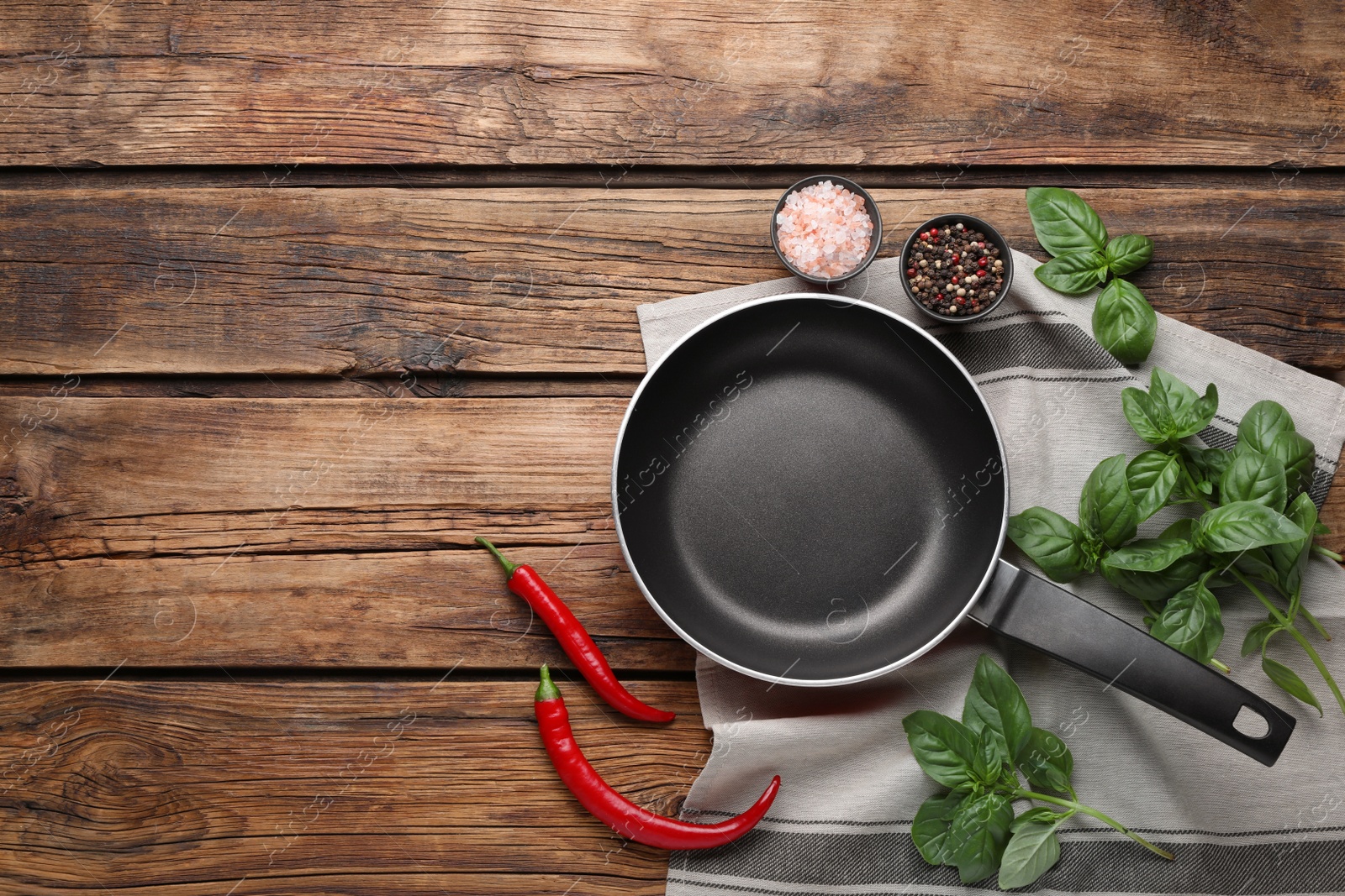 Photo of Flat lay composition with frying pan and fresh products on wooden table, space for text