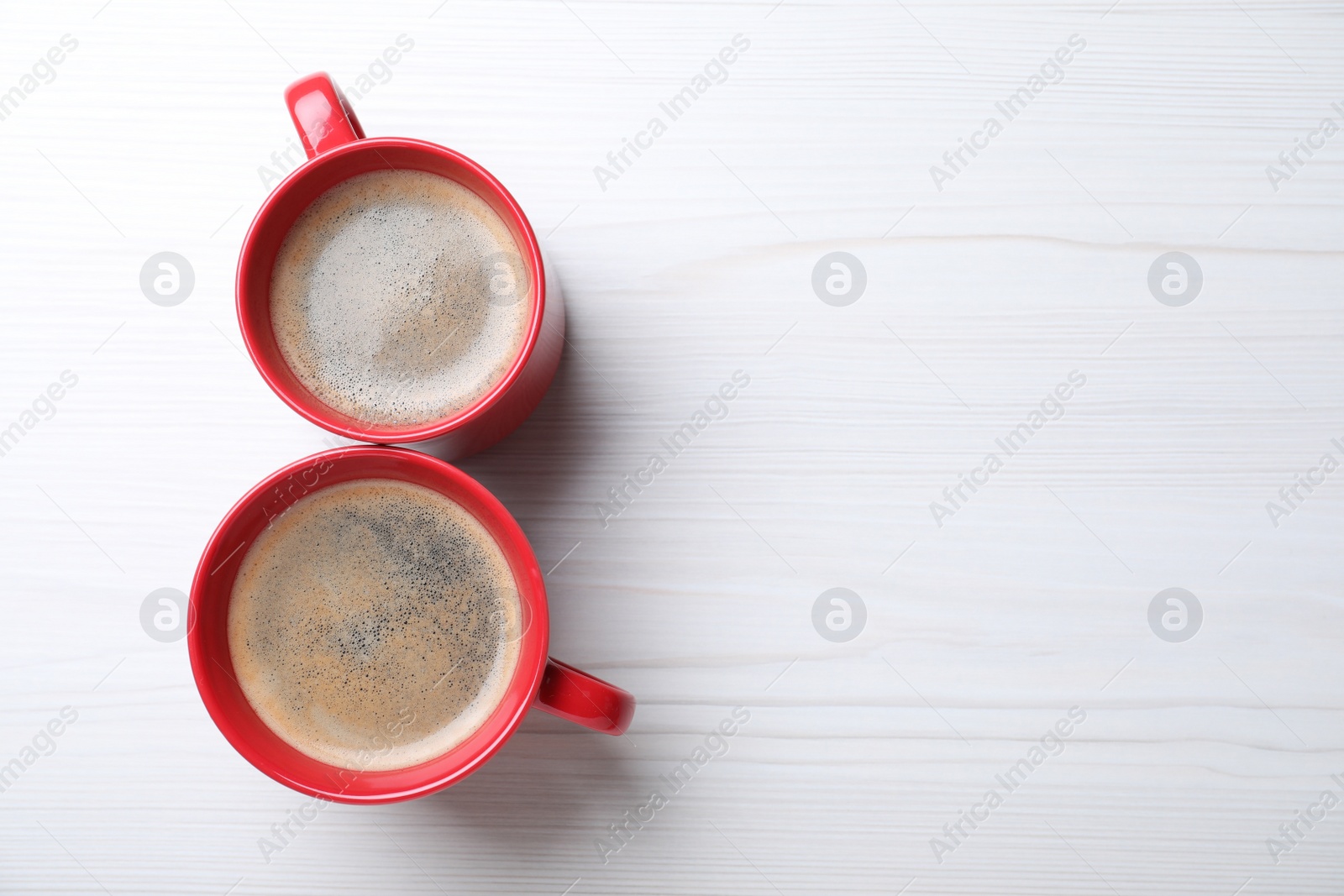 Photo of 8 March greeting card design with cups of coffee and space for text on white wooden background, flat lay. International Women's day