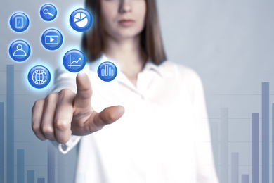 Image of Data management system. Woman pointing at virtual icon on grey background