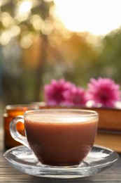 Glass cup with coffee on wooden table. Morning ritual