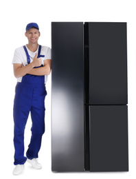 Professional worker near refrigerator on white background