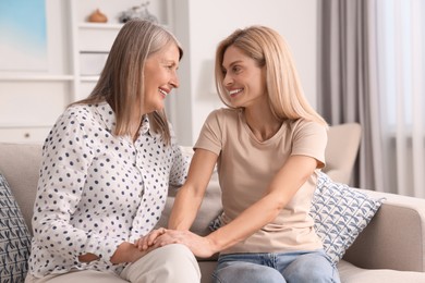 Happy mature mother and her daughter spending time together at home