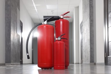 Three new red fire extinguishers in hall