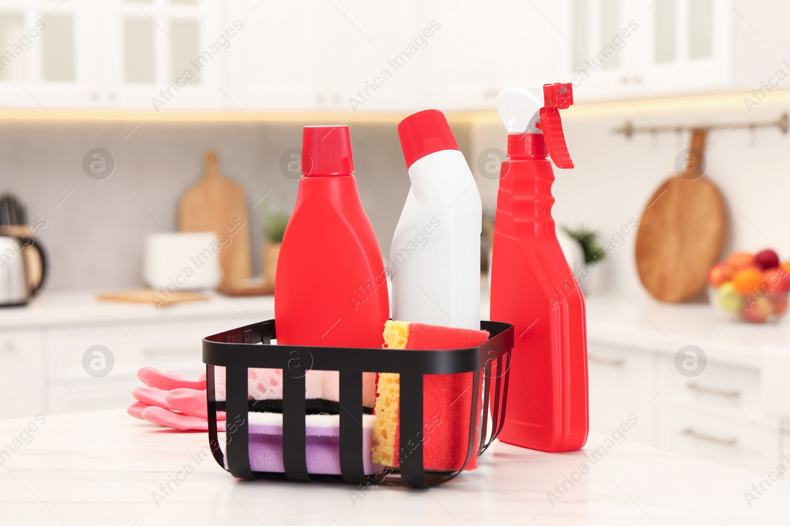 Photo of Different cleaning supplies in basket on table