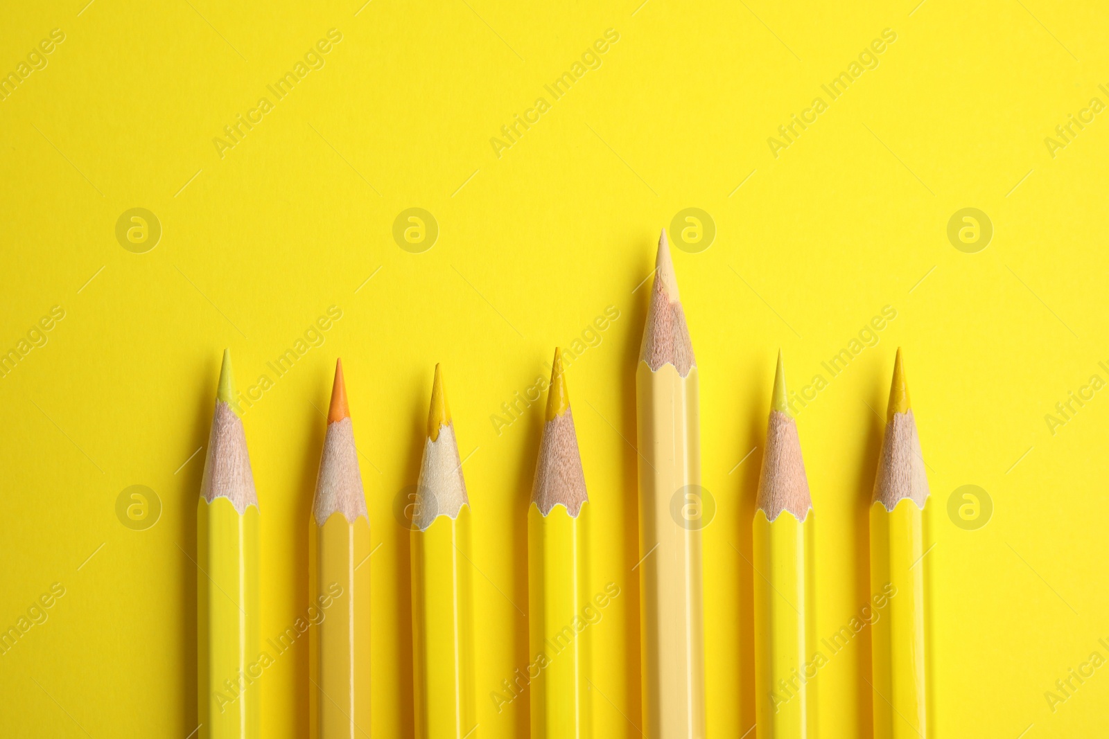 Photo of Flat lay composition with color pencils on yellow background