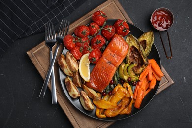 Photo of Tasty cooked salmon and vegetables served on black table, flat lay. Healthy meals from air fryer