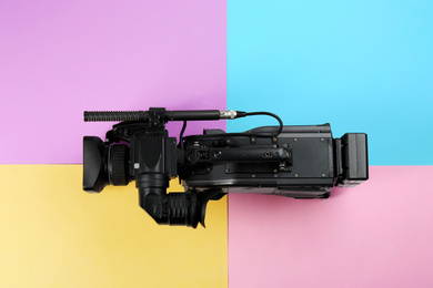 Photo of Modern video camera on color background, top view