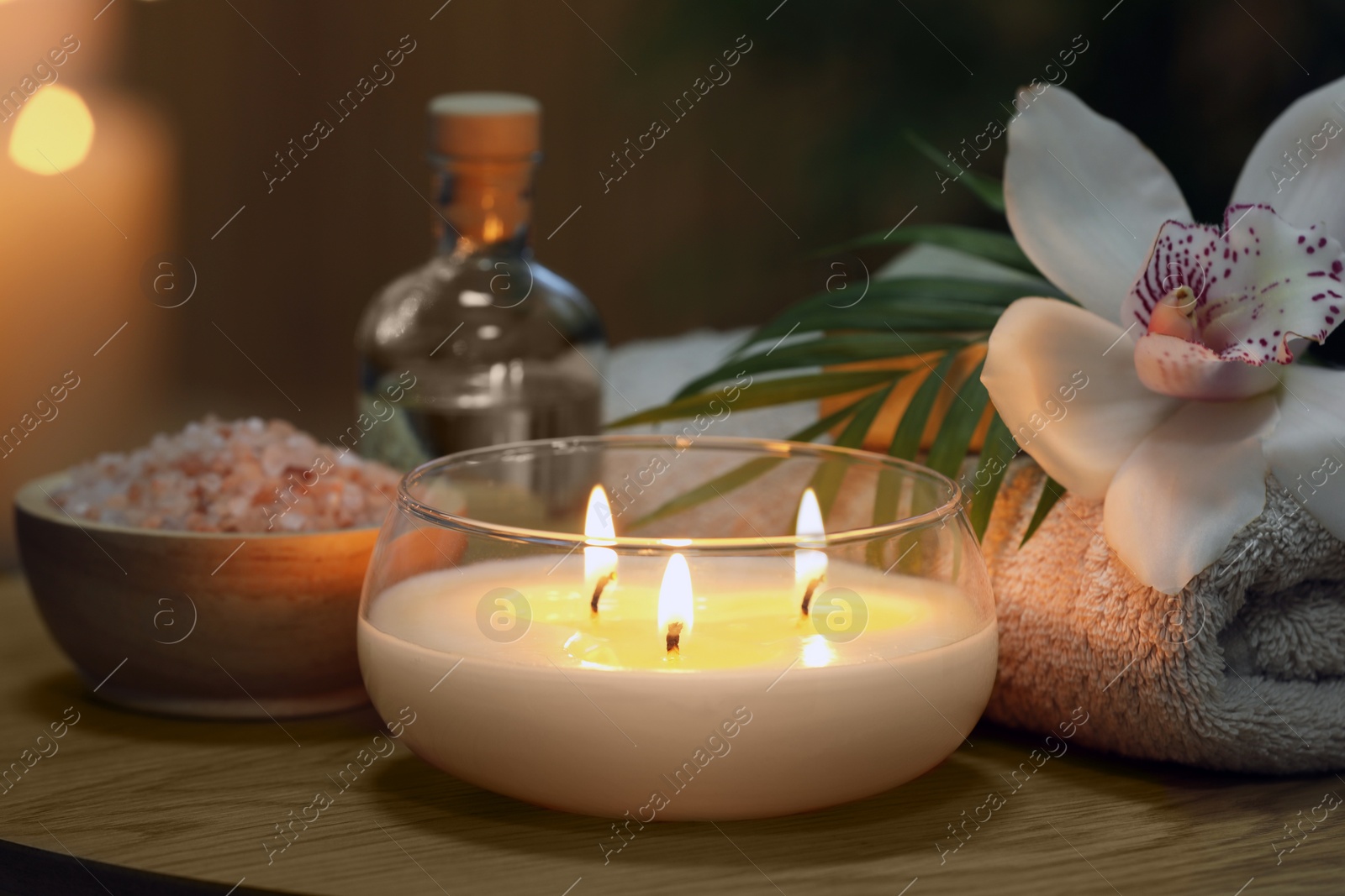 Photo of Beautiful spa composition with burning candle on wooden table, closeup