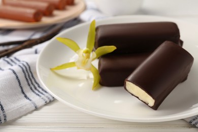 Photo of Glazed vanilla curd cheese bars served on white wooden table, closeup