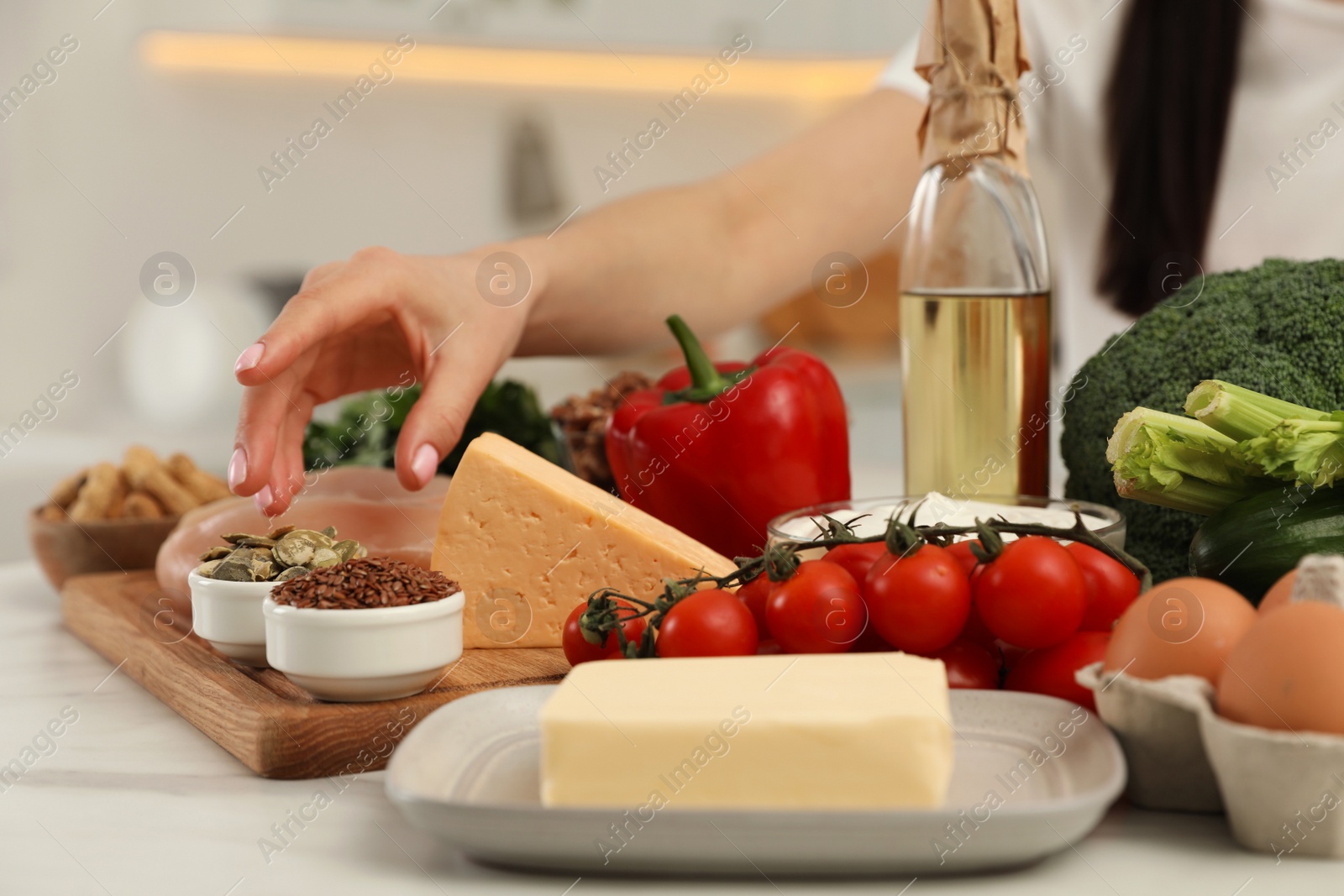 Photo of Woman with different products at table, closeup. Keto diet