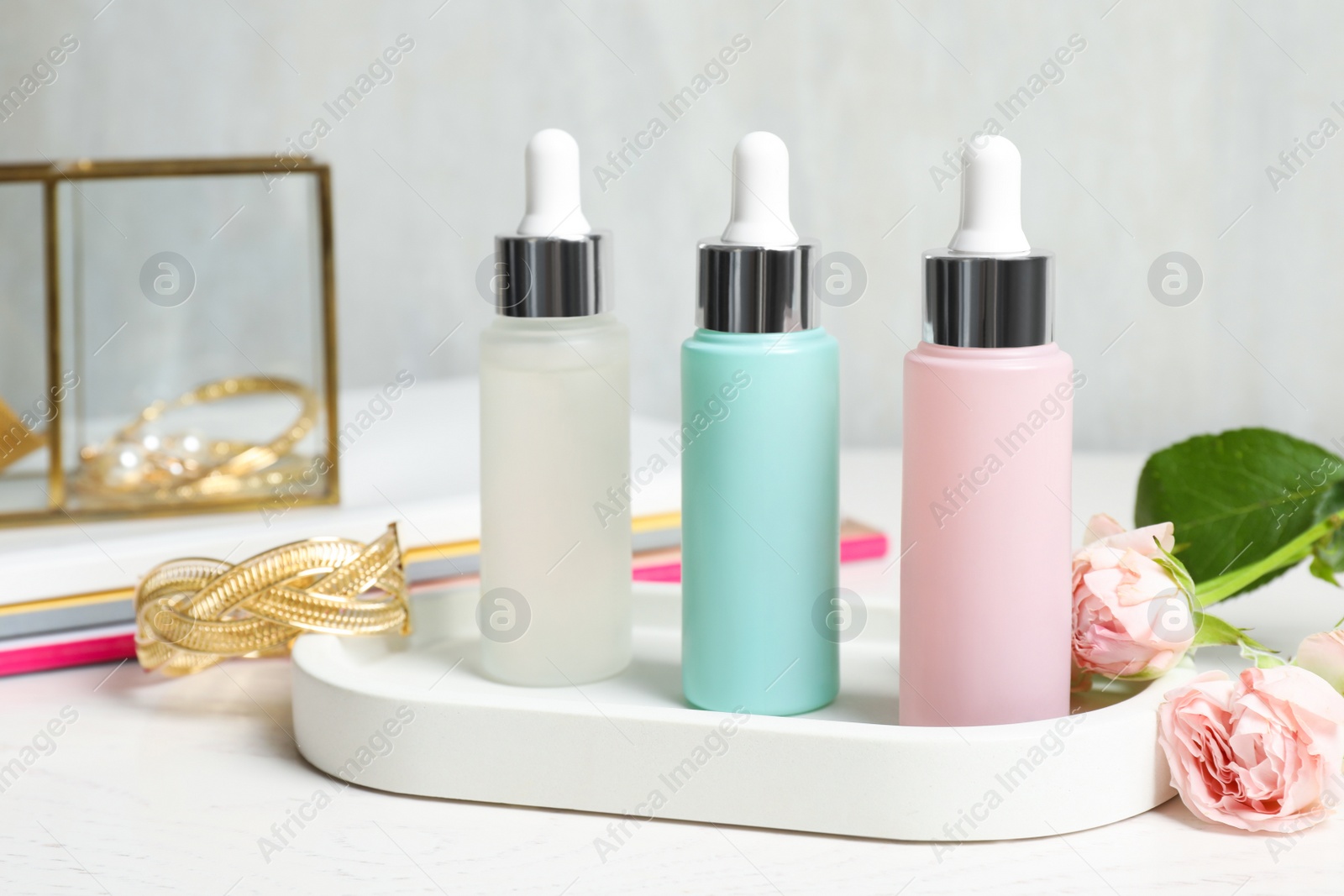 Photo of Different cosmetic products and ring on white table