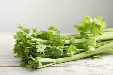 Fresh ripe green celery on white wooden table, closeup