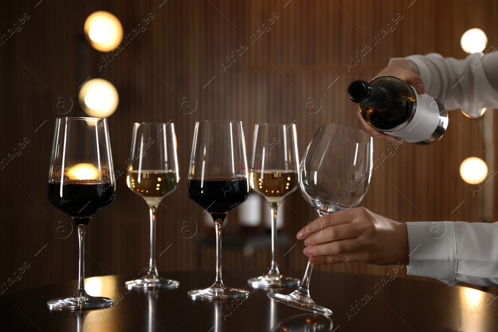 Photo of Waitress pouring wine into glass in restaurant, closeup