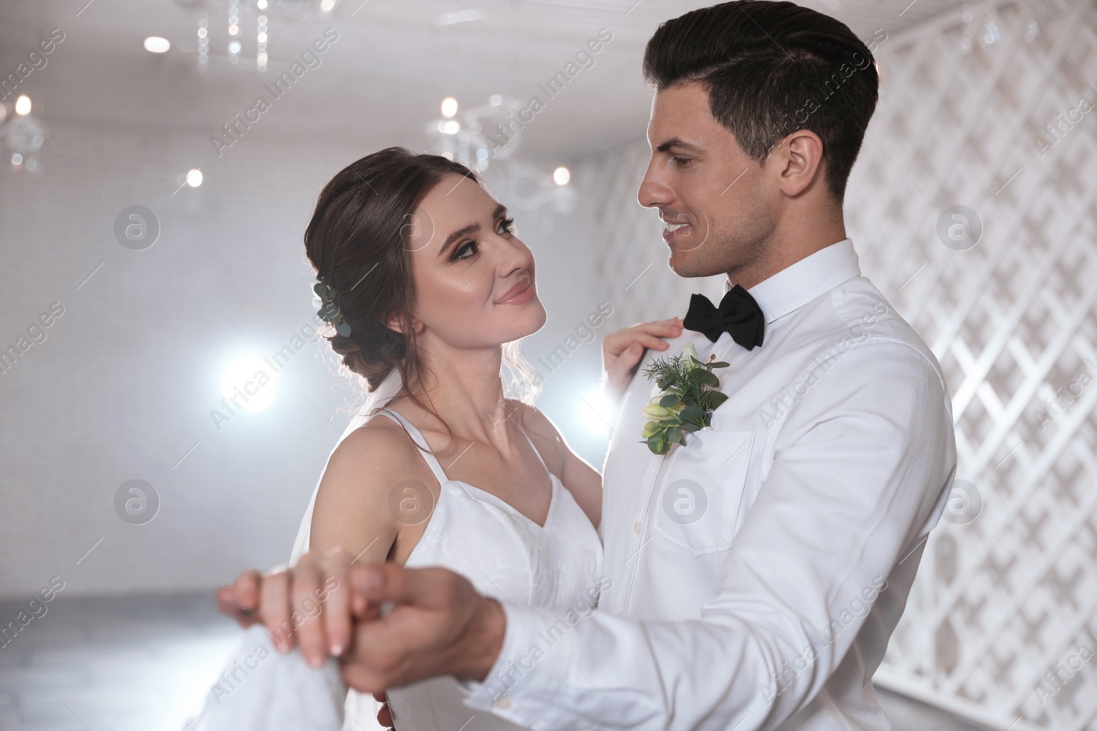 Photo of Happy newlywed couple dancing together in festive hall