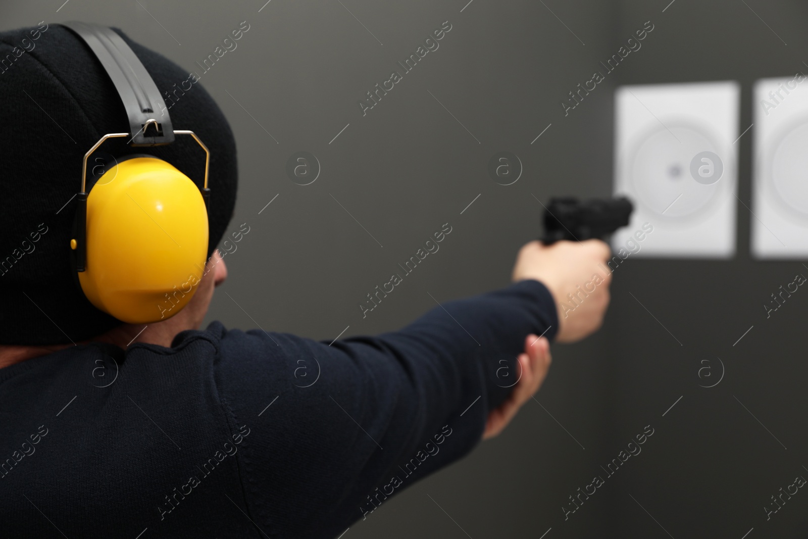 Photo of Man aiming at shooting target indoors, closeup