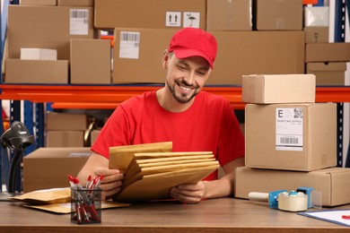 Post office worker with adhesive paper bags at counter indoors