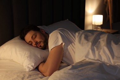 Photo of Handsome man sleeping in bed at night