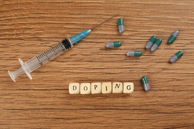 Cubes with word Doping and drugs on wooden background, flat lay