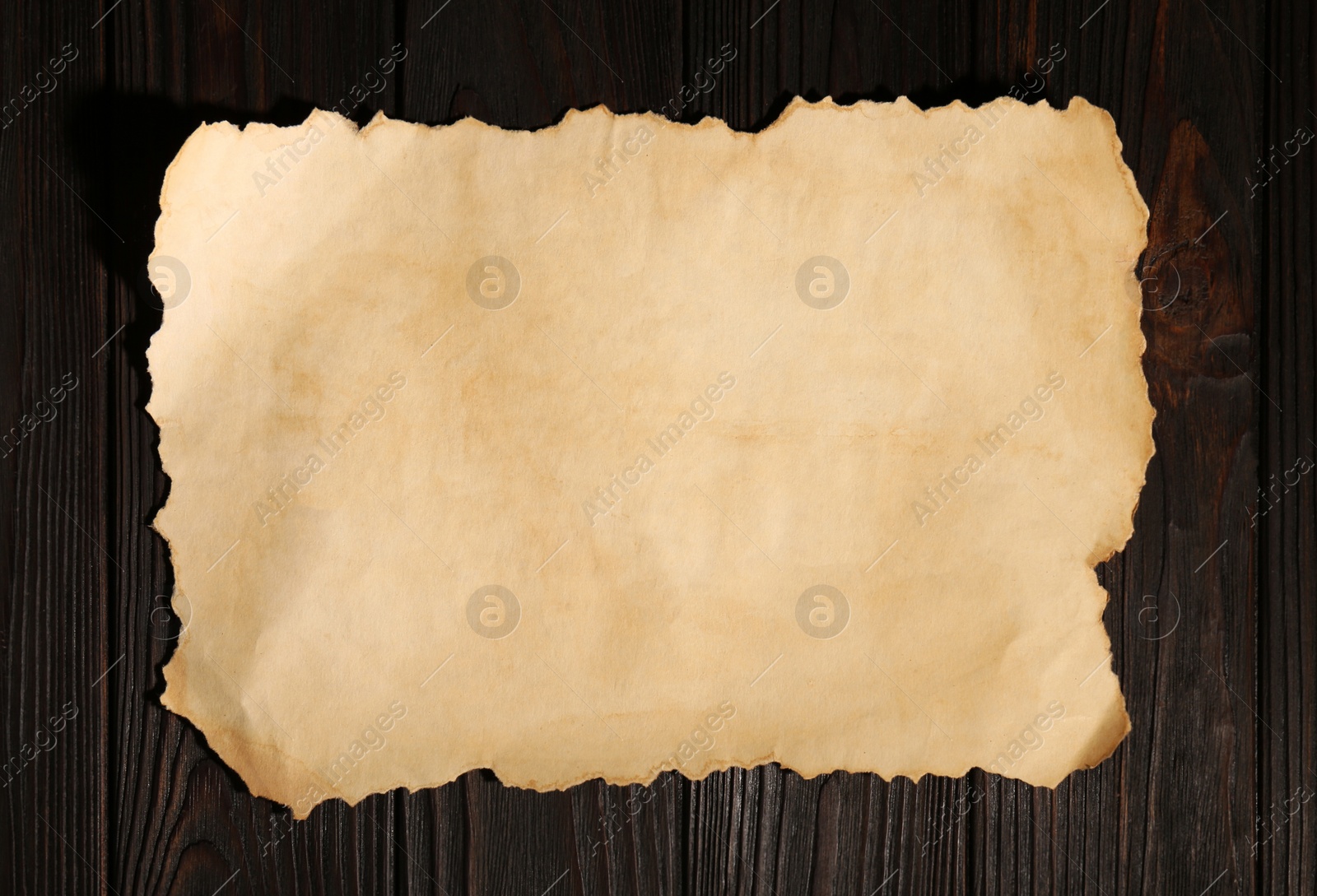 Photo of Sheet of old parchment paper on wooden table, top view