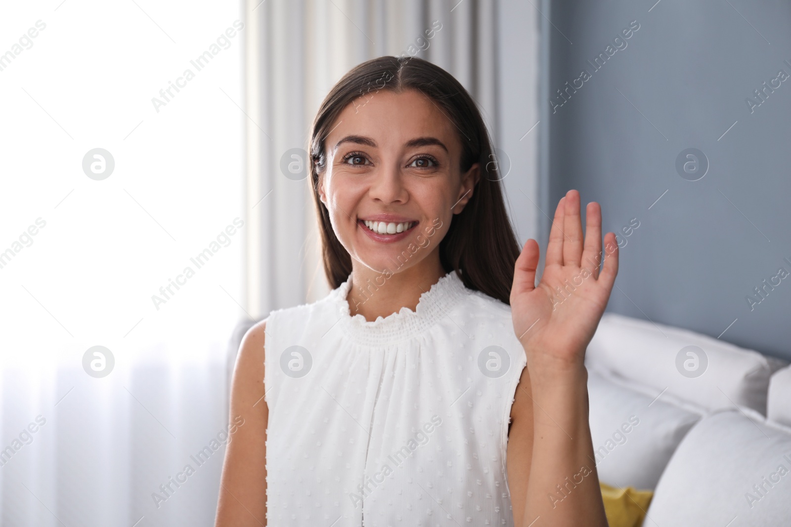 Photo of Young woman talking to his coworkers through video conference indoors, view from webcam