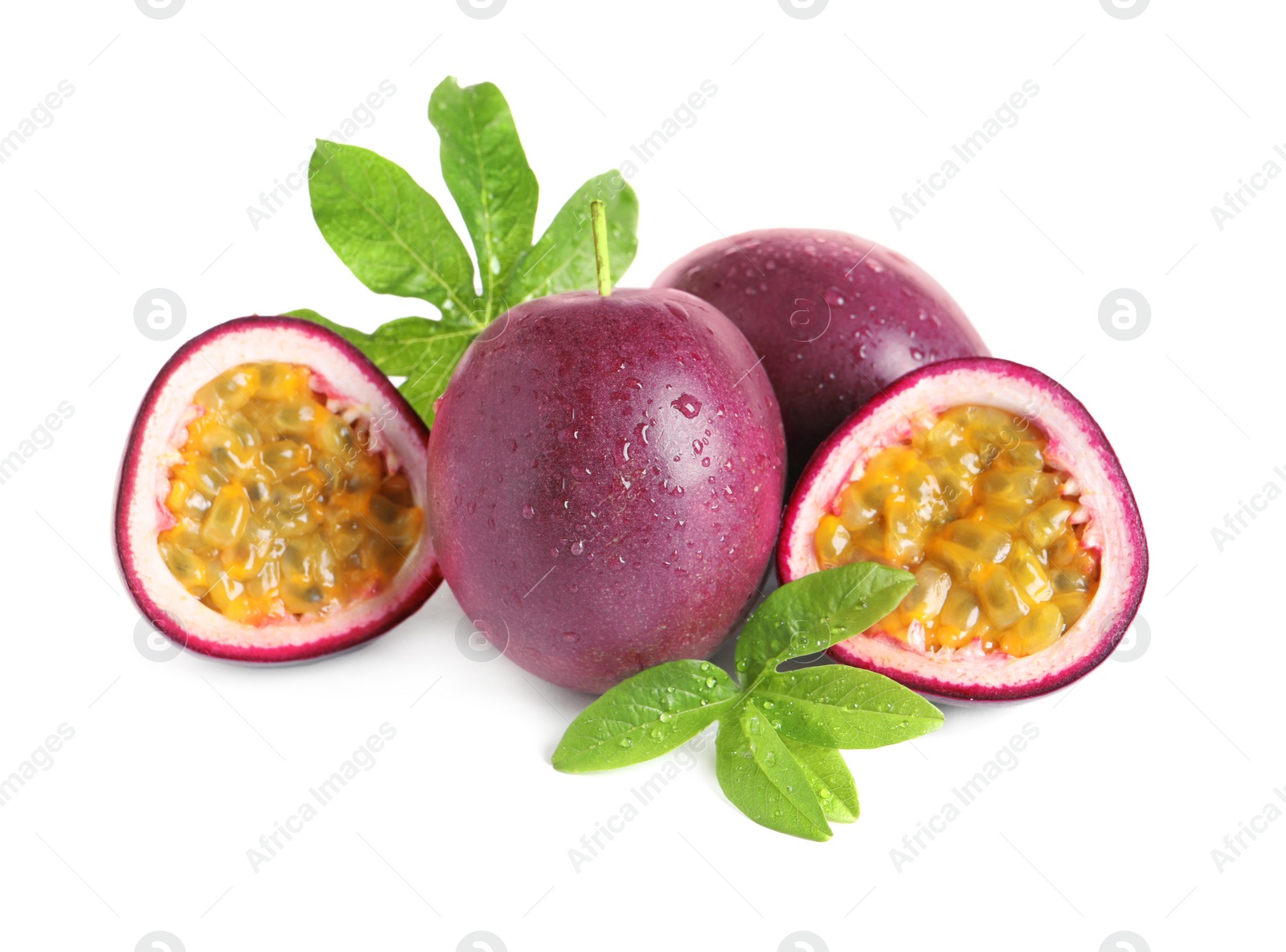 Photo of Cut and whole passion fruits with leaves isolated on white