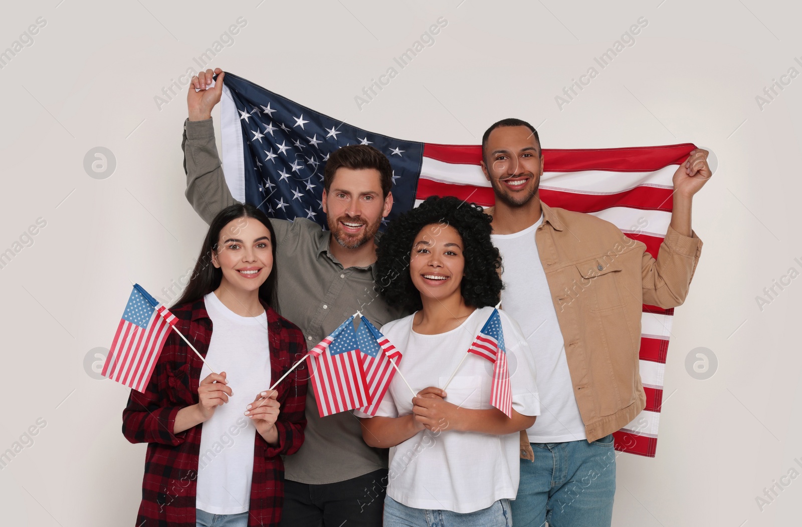 Photo of 4th of July - Independence Day of USA. Happy friends with American flags on white background