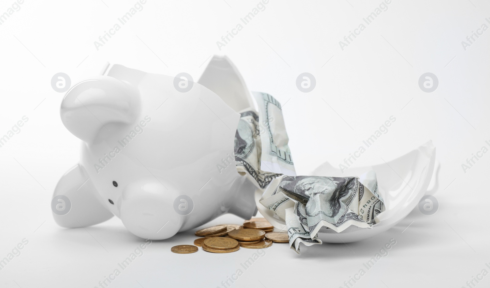 Photo of Broken piggy bank with coins and banknotes on white background