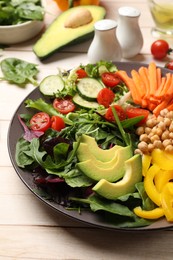 Photo of Balanced diet and vegetarian foods. Plate with different delicious products on wooden table