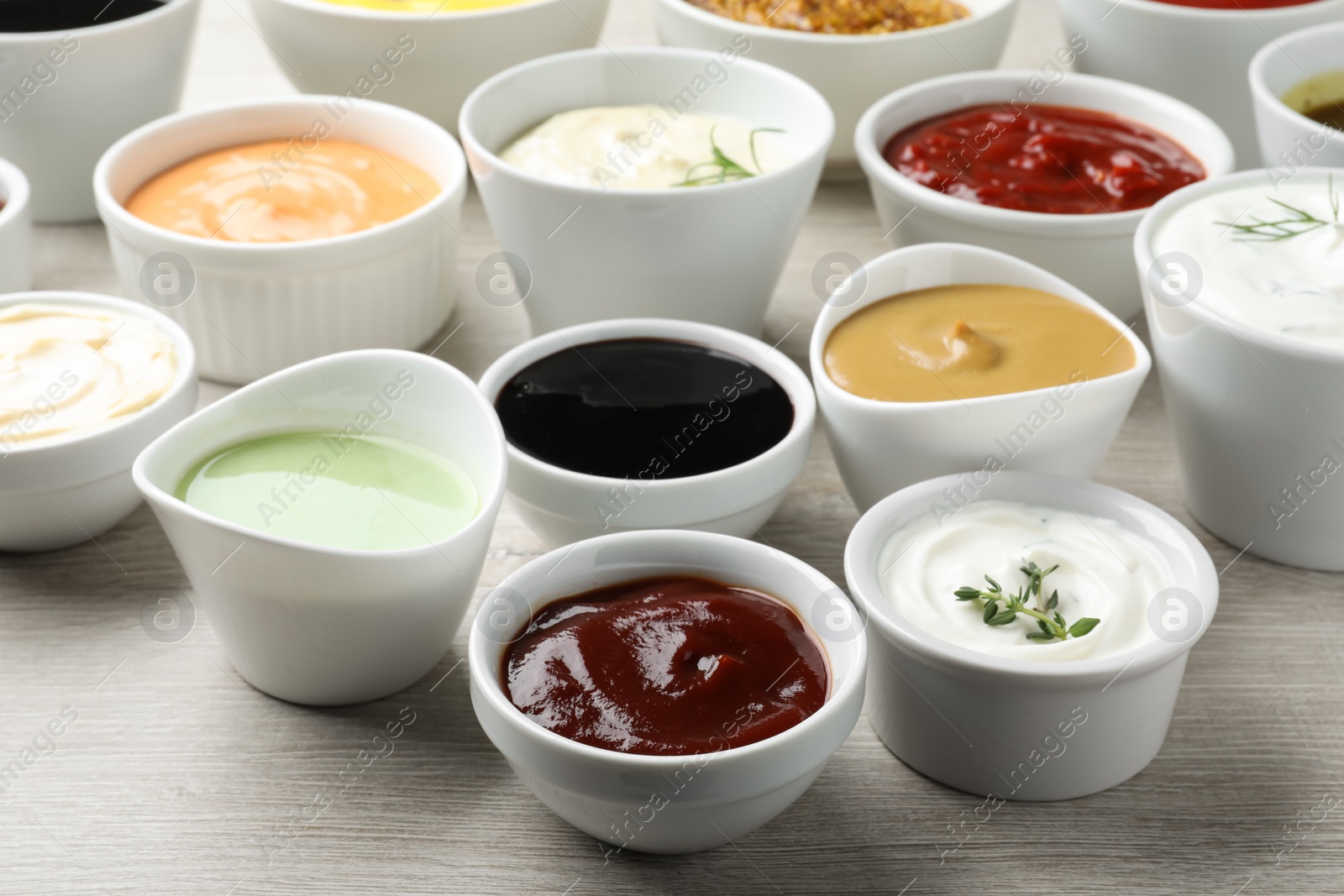 Photo of Many different sauces on white wooden table