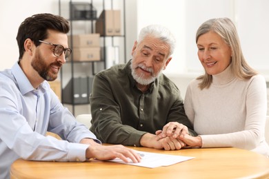 Notary consulting senior couple about Last Will and Testament in office