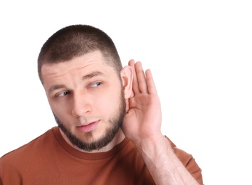 Young man with hearing problem on white background