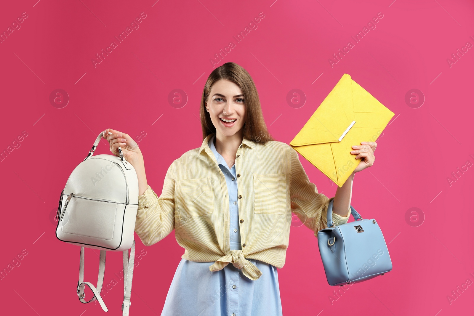 Photo of Beautiful young woman with stylish bags on pink background