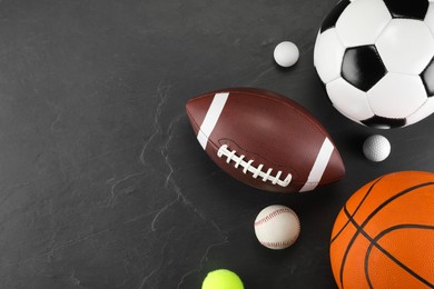 Photo of Many different sports balls on dark gray background, flat lay. Space for text