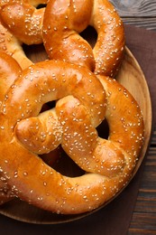 Photo of Tasty freshly baked pretzels on wooden table, top view