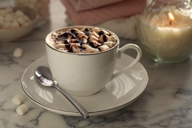 Photo of Cup of aromatic hot chocolate with marshmallows served on light marble table, closeup