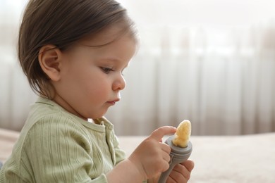 Photo of Cute baby girl with nibbler at home